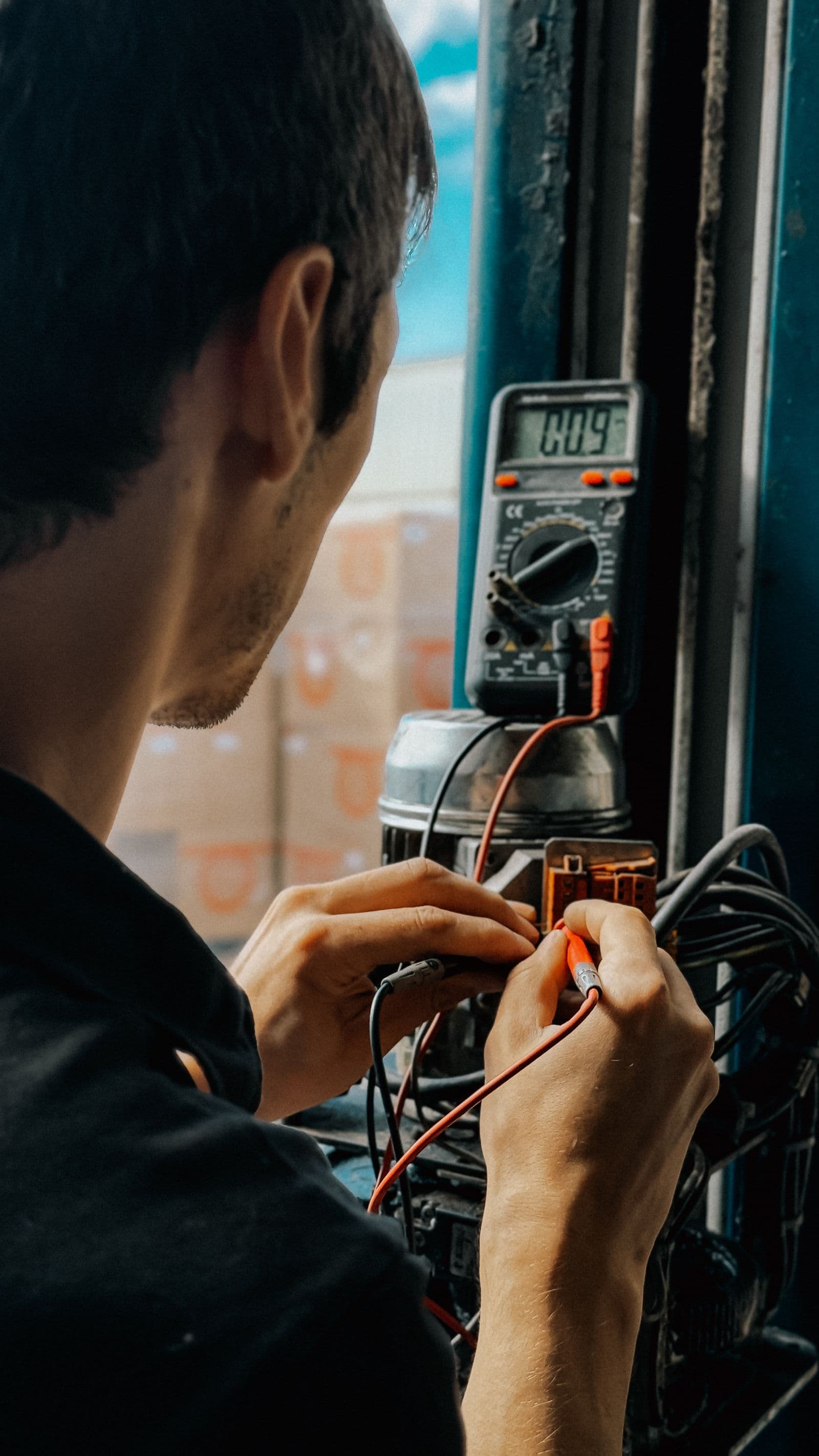 Un técnico probando equipos eléctricos con un multímetro.