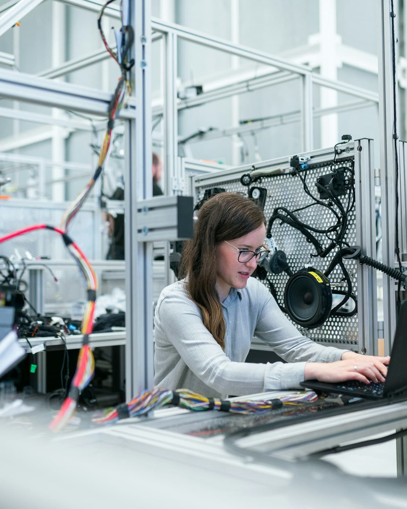 An engineer working on a laptop in a technical lab.